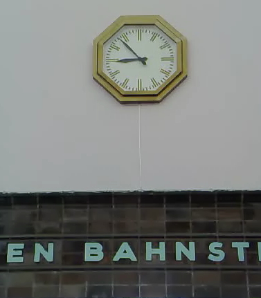 Historische Uhr im Bahnhof Berlin-Wannsee. Die achteckige Form nimmt den Grundriss der Schalterhalle, wo sie über dem Treppenaufgang hängt, wieder auf.
